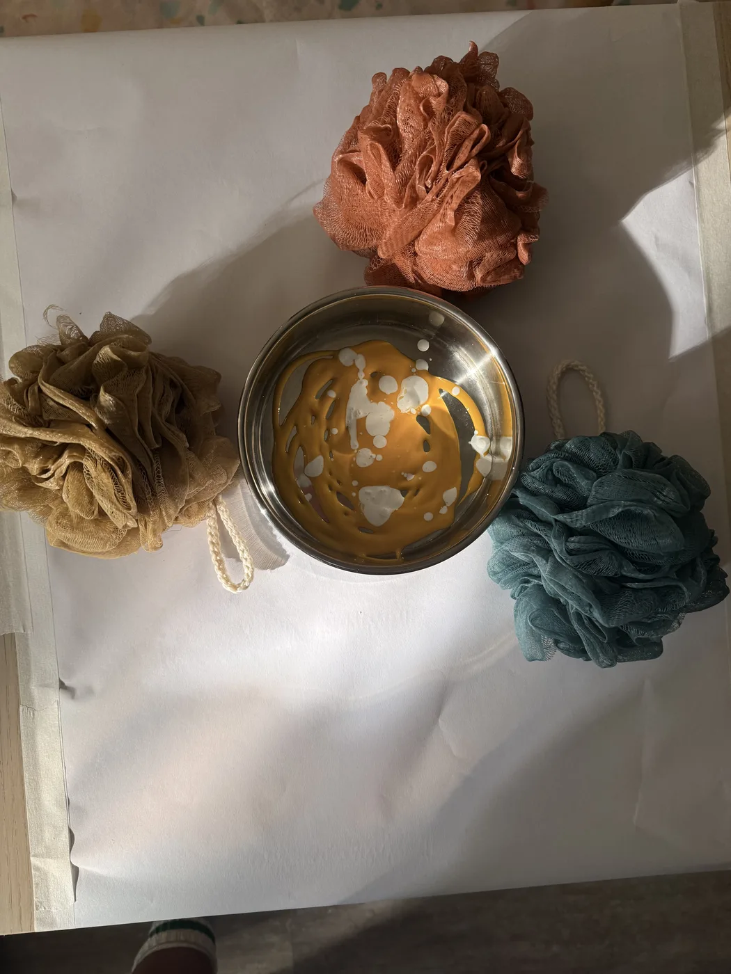 A provocation of sponges and a bowl of paint arranged on paper before the children arrive